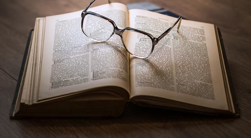 Blick auf aufgeschlagenes Buch mit Brille